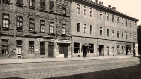 Ansicht der Brünnerstraße aus den 1930er Jahren mit gepflasterer Straße und zwei zweistöckigen Häusern mit teilweise stark abbröckelnder Fassade